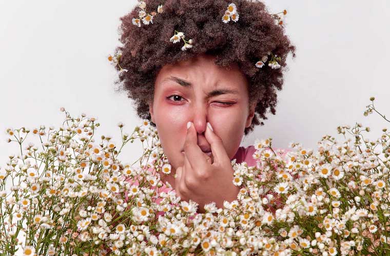 femme fait une allergie à côté de fleurs