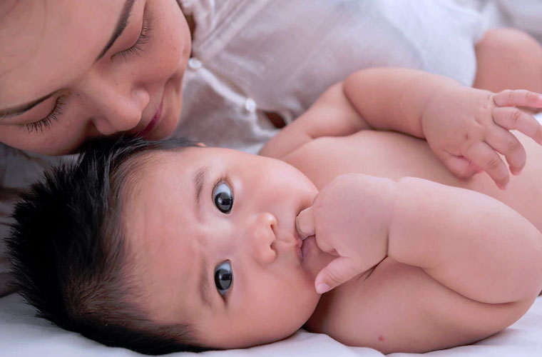 bébé allongé à côté de sa maman