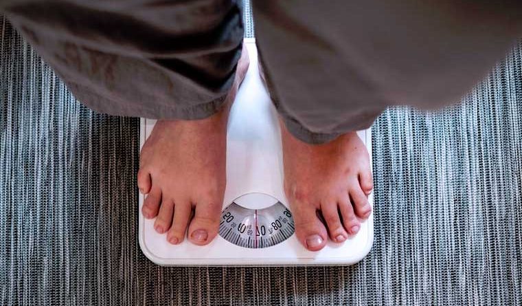 personne en train de se peser sur une balance
